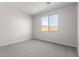 Bright bedroom with soft gray carpet and a window at 17868 W Blue Sky Dr, Surprise, AZ 85387