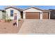 Inviting single-story home showcasing a two-car garage and terracotta roofing against a clear blue sky at 17868 W Blue Sky Dr, Surprise, AZ 85387