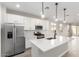 Stylish kitchen featuring stainless steel appliances, white cabinets and island, complemented by modern lighting at 17868 W Blue Sky Dr, Surprise, AZ 85387