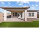 A covered backyard patio features well manicured lawn and neutral colored stucco and rock landscaping at 19341 W San Juan Ave, Litchfield Park, AZ 85340