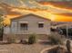Charming single-story home with desert landscaping and covered parking under a vibrant sunset sky at 201 S Greenfield Rd # 271, Mesa, AZ 85206