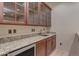 Well-equipped wet bar with granite countertops and glass-front cabinets at 2322 E Samantha Way, Phoenix, AZ 85042