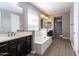 Bathroom with double vanity, soaking tub and grey wood-look tile floor at 3943 E Canyon Pl, Chandler, AZ 85249