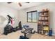 Home gym with elliptical, weights and bookshelf at 7341 E Sutton Dr, Scottsdale, AZ 85260