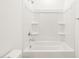 A new bathroom in a new home has a bright white tub and shower at 17703 W Southgate Ave, Goodyear, AZ 85338