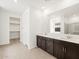 Bright bathroom featuring double sinks and a walk-in closet at 17703 W Southgate Ave, Goodyear, AZ 85338