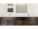 Bathroom featuring double sinks, white countertop and dark cabinets at 17703 W Southgate Ave, Goodyear, AZ 85338