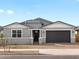Charming single-story home with a well-manicured lawn, gray paint, and an attached two-car garage at 17703 W Southgate Ave, Goodyear, AZ 85338