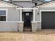 Close up view of the home's brick-paved entryway, leading to a gated entrance with a black front door at 17703 W Southgate Ave, Goodyear, AZ 85338