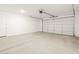 Spacious two car garage with concrete floor and white door at 17703 W Southgate Ave, Goodyear, AZ 85338