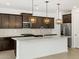 Modern kitchen featuring dark wood cabinets, stainless steel appliances, white countertop, and pendant lighting at 17703 W Southgate Ave, Goodyear, AZ 85338