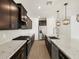 Spacious kitchen featuring dark wood cabinets, stainless steel appliances, white countertop, and wood floors at 17703 W Southgate Ave, Goodyear, AZ 85338