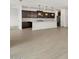 Open floor plan with wood-look tile flooring throughout living spaces and into kitchen at 17703 W Southgate Ave, Goodyear, AZ 85338