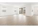 Large living room features wood-look tile flooring, white walls, and lots of natural light at 17703 W Southgate Ave, Goodyear, AZ 85338