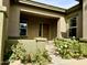 Charming front porch with a rustic wood door, green plants, and an inviting ambiance at 20856 E Arroyo Verde Dr, Queen Creek, AZ 85142