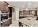 Bright kitchen featuring stainless steel appliances, granite counters, an island, and dark wood cabinetry at 20856 E Arroyo Verde Dr, Queen Creek, AZ 85142