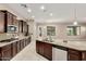 Spacious kitchen featuring dark wood cabinets, granite countertops, stainless steel appliances and tiled floor at 20856 E Arroyo Verde Dr, Queen Creek, AZ 85142