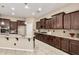 Gourmet kitchen featuring dark cabinets, island with sink, granite counters and stainless appliances at 20856 E Arroyo Verde Dr, Queen Creek, AZ 85142
