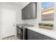 Bright laundry room featuring modern washer, dryer, and stylish cabinetry at 32427 N 71St Way, Scottsdale, AZ 85266