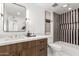 Bright bathroom with wood vanity, black and white striped shower, and neutral decor at 8531 E San Miguel Ave, Scottsdale, AZ 85250