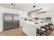 Modern kitchen featuring stainless steel appliances, an island with seating, and sleek, all-white cabinetry at 8531 E San Miguel Ave, Scottsdale, AZ 85250