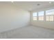 Bedroom with three windows and grey carpet flooring at 12028 N Luckenbach St, Surprise, AZ 85388