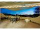 Evening view from covered patio with seating area and fire pit at 13503 E Charter Oak Dr, Scottsdale, AZ 85259