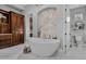 Bathroom with a free-standing bathtub and hexagon tile feature wall at 20668 E Sunset Dr, Queen Creek, AZ 85142