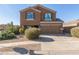 Two-story house with a tan exterior, two-car garage, and landscaping at 306 N 21St Cir, Coolidge, AZ 85128