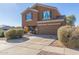 Two-story house with a tan exterior, two-car garage, and landscaping at 306 N 21St Cir, Coolidge, AZ 85128