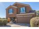 Two-story house with a tan exterior, two-car garage, and landscaping at 306 N 21St Cir, Coolidge, AZ 85128