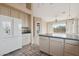 Open kitchen with ample cabinetry, tile countertops, white appliances, and large windows at 5217 S Crested Saguaro Ln, Gold Canyon, AZ 85118