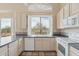 Well-lit kitchen with white appliances, tile countertops, and a window overlooking the backyard at 5217 S Crested Saguaro Ln, Gold Canyon, AZ 85118