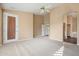 A sun-filled primary bedroom with a ceiling fan, plush neutral carpet and closet at 5217 S Crested Saguaro Ln, Gold Canyon, AZ 85118