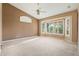 A spacious primary bedroom boasts a ceiling fan, bay windows and neutral carpet at 5217 S Crested Saguaro Ln, Gold Canyon, AZ 85118