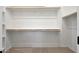 A walk-in closet features white walls and multiple shelves with wooden support beams at 17316 W Via Dona Rd, Surprise, AZ 85387