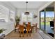 Bright dining room with wooden table and chairs, near sliding glass doors at 2453 N 211Th Ln, Buckeye, AZ 85396