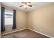 Spacious bedroom with ceiling fan and carpeted floors at 41369 W Crane Dr, Maricopa, AZ 85138