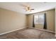 Spacious bedroom with ceiling fan, carpet flooring, and large window at 41369 W Crane Dr, Maricopa, AZ 85138