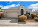 One-story house with tan exterior, landscaped yard, and a two-car garage at 41369 W Crane Dr, Maricopa, AZ 85138