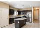 Kitchen features dark cabinets, granite countertops, and stainless steel appliances at 41369 W Crane Dr, Maricopa, AZ 85138