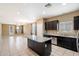 Open kitchen with dark cabinetry, granite countertops, and stainless steel appliances at 41369 W Crane Dr, Maricopa, AZ 85138