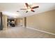 Spacious living room with tile floors, ceiling fan, and views into kitchen at 41369 W Crane Dr, Maricopa, AZ 85138