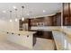 This gourmet kitchen features stainless steel appliances, granite countertops and a large island with pendant lighting at 5531 W Gwen St, Laveen, AZ 85339