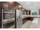 This gourmet kitchen features stainless steel appliances and granite countertops with beautiful dark wood cabinetry at 5531 W Gwen St, Laveen, AZ 85339