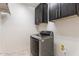 Well-equipped laundry room includes upper cabinets and modern washing machine for efficient laundry tasks at 5531 W Gwen St, Laveen, AZ 85339