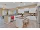 Spacious kitchen with white cabinetry, island, and breakfast bar at 27486 N 89Th Dr, Peoria, AZ 85383
