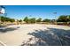 Outdoor basketball court with multiple hoops, surrounded by trees, perfect for community games and recreation at 40015 W Crane Dr, Maricopa, AZ 85138