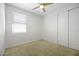 Bright bedroom with a ceiling fan, closet, and window providing natural light at 40015 W Crane Dr, Maricopa, AZ 85138