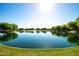 A tranquil lake is framed by trees providing a calming view and a great place to relax at 40015 W Crane Dr, Maricopa, AZ 85138